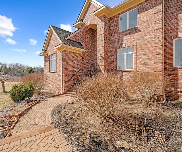 view of side of home with brick siding