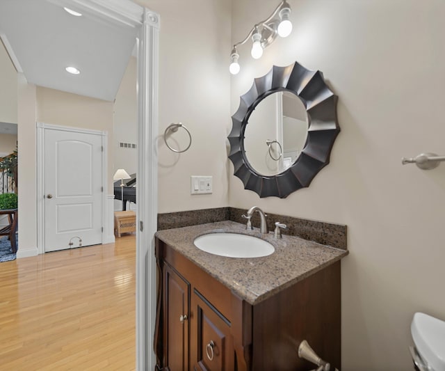 bathroom featuring visible vents, toilet, wood finished floors, and vanity