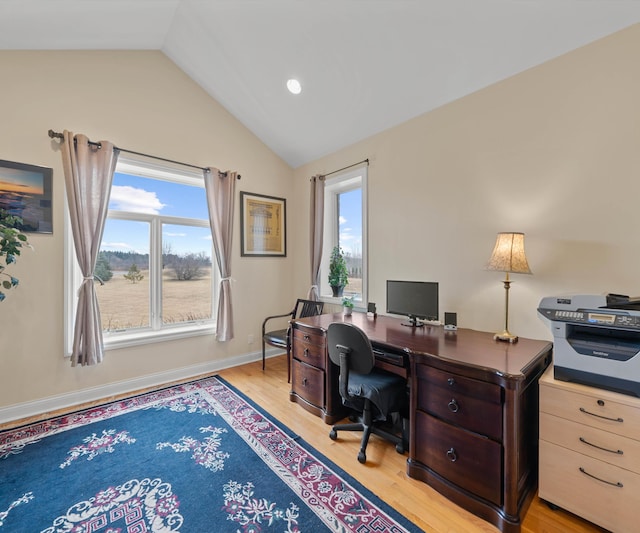 home office featuring baseboards, lofted ceiling, plenty of natural light, and light wood-style flooring