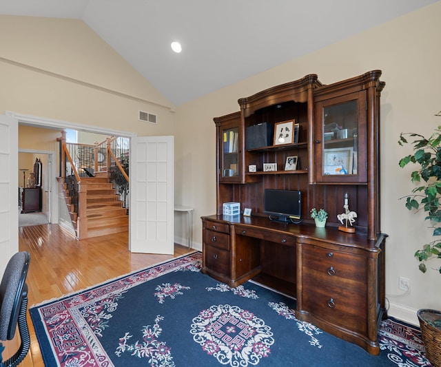 office area featuring visible vents, wood finished floors, baseboards, and vaulted ceiling