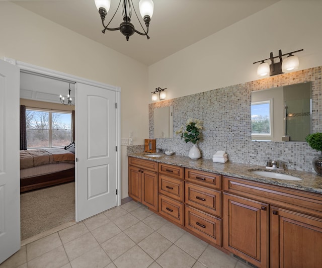 bathroom featuring double vanity, a notable chandelier, backsplash, and a sink