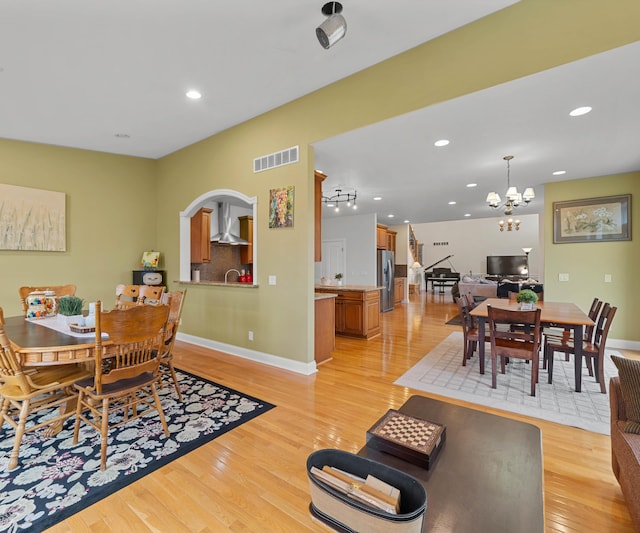 dining room featuring light wood finished floors, visible vents, recessed lighting, and baseboards