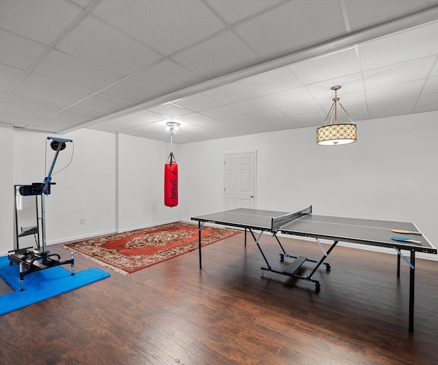 playroom with a drop ceiling, baseboards, and wood finished floors