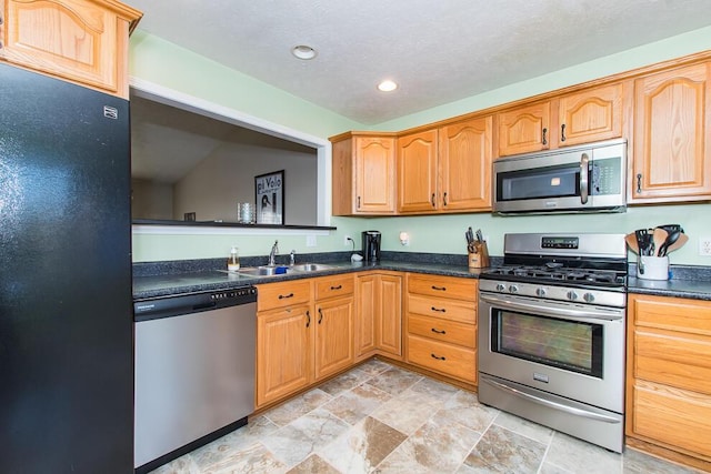 kitchen with a sink, dark countertops, recessed lighting, and stainless steel appliances