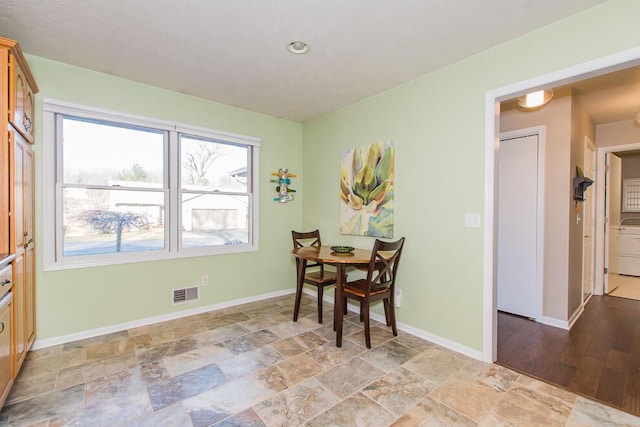 dining area with visible vents, baseboards, and stone finish floor