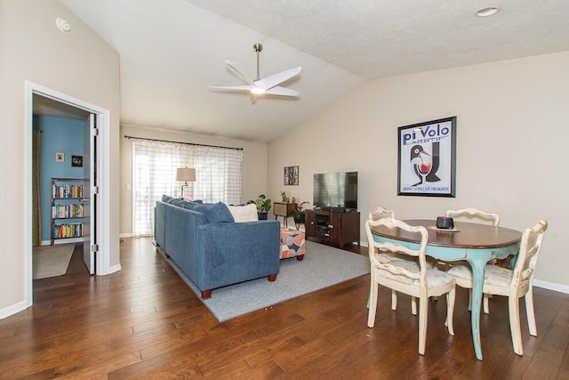 living area with dark wood-style floors, ceiling fan, baseboards, and vaulted ceiling