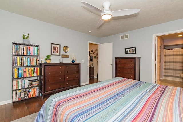 bedroom featuring ensuite bath, wood finished floors, visible vents, and baseboards