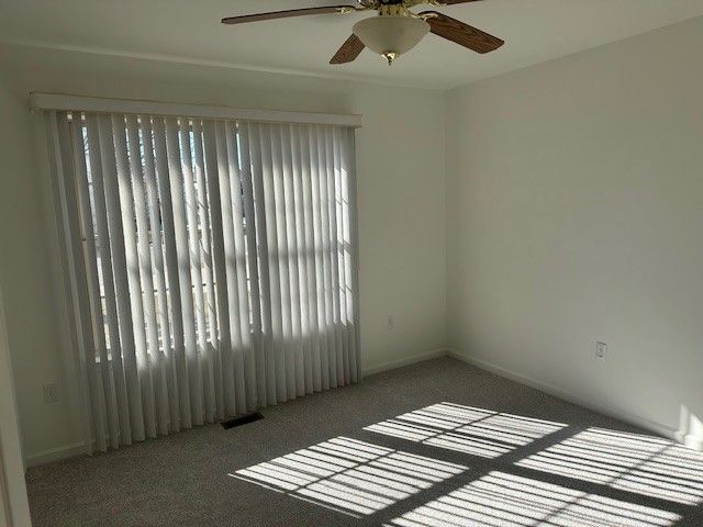 empty room featuring visible vents and carpet