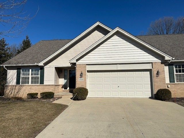 single story home with concrete driveway and an attached garage