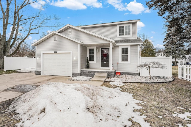 traditional home with concrete driveway, an attached garage, and fence