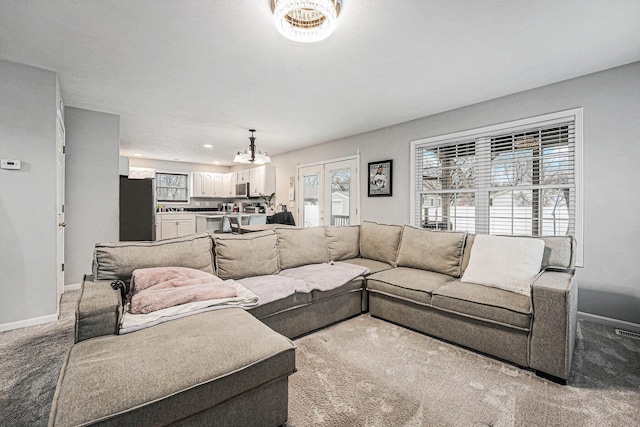 living room featuring carpet, baseboards, and french doors