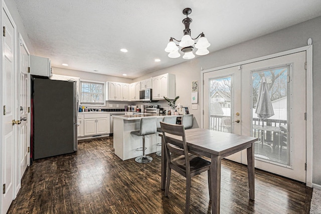 dining area with dark wood-type flooring, french doors, recessed lighting, and a wealth of natural light