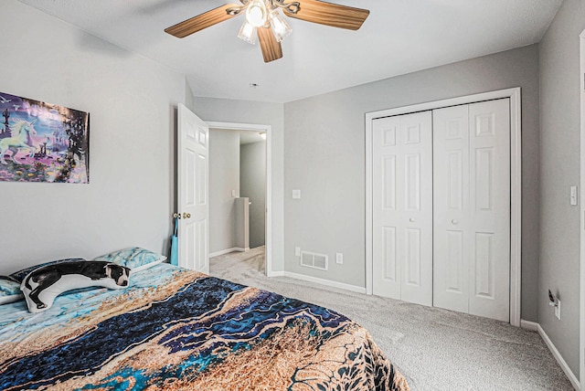 bedroom with visible vents, a ceiling fan, a closet, baseboards, and light colored carpet