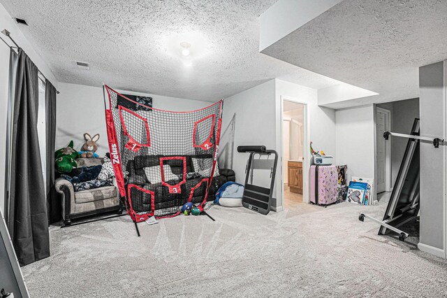 workout area featuring a textured ceiling and carpet floors