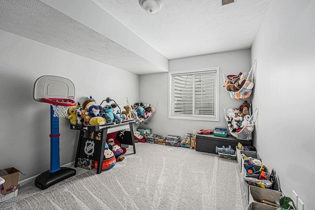 recreation room with carpet floors and a textured ceiling