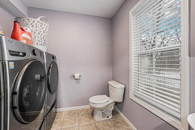 laundry room featuring light tile patterned floors, baseboards, laundry area, and washer and clothes dryer