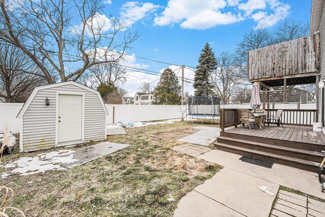 view of yard with a fenced backyard, a storage unit, an outdoor structure, and a trampoline