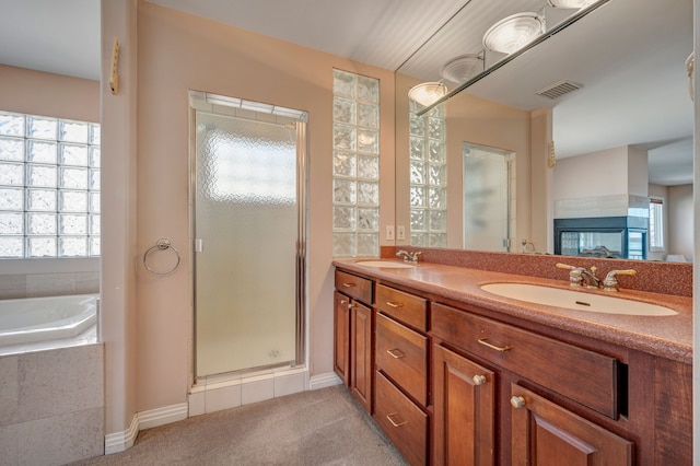 bathroom featuring a sink, visible vents, a garden tub, and a shower stall