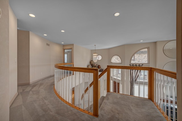 hall featuring recessed lighting, an upstairs landing, and light colored carpet