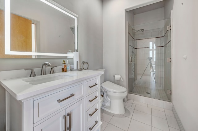 bathroom featuring vanity, baseboards, tile patterned flooring, a shower stall, and toilet