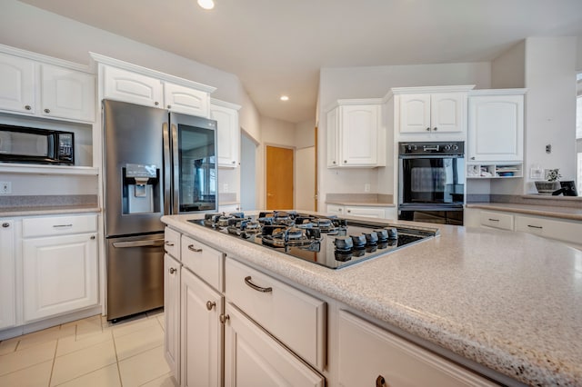 kitchen with light tile patterned floors, light stone counters, recessed lighting, white cabinets, and black appliances