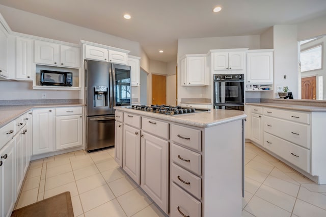 kitchen with light tile patterned flooring, recessed lighting, black appliances, white cabinetry, and a center island