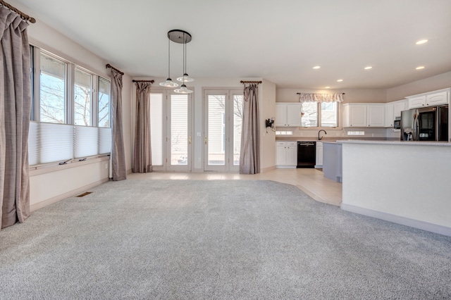 kitchen featuring fridge with ice dispenser, light colored carpet, dishwasher, and white cabinetry