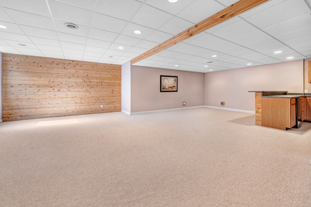 finished basement featuring light carpet, wooden walls, recessed lighting, and visible vents