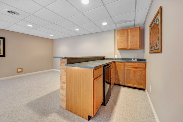 kitchen featuring baseboards, visible vents, a peninsula, a sink, and light colored carpet