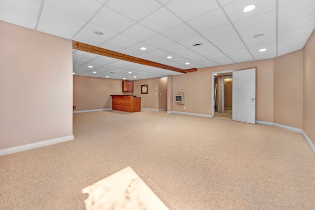 below grade area featuring baseboards, a drop ceiling, carpet floors, recessed lighting, and heating unit