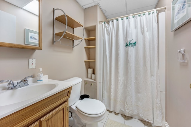 full bathroom with tile patterned flooring, curtained shower, a drop ceiling, toilet, and vanity