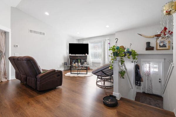 living room with visible vents, recessed lighting, lofted ceiling, and wood finished floors