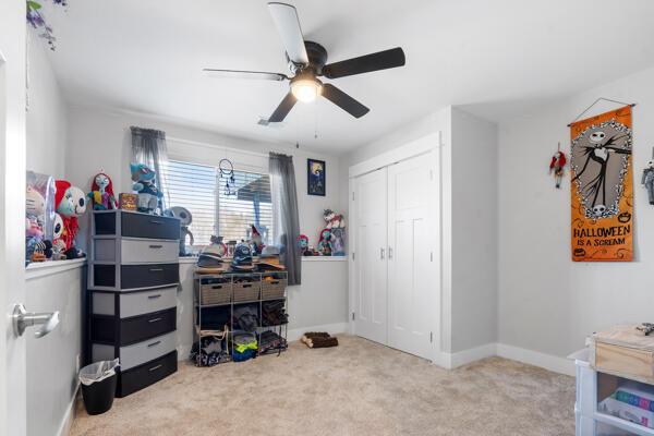 bedroom featuring a closet, carpet floors, baseboards, and a ceiling fan