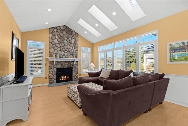 living room with light wood-style flooring, recessed lighting, a fireplace, and high vaulted ceiling