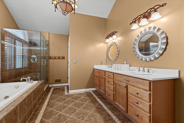 bathroom featuring a garden tub, a stall shower, a sink, tile patterned flooring, and baseboards