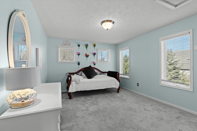 bedroom featuring carpet, baseboards, and a textured ceiling