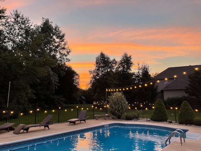 pool at dusk with a fenced in pool, a patio, and fence