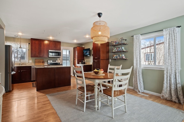 dining area with light wood finished floors, recessed lighting, a healthy amount of sunlight, and baseboards