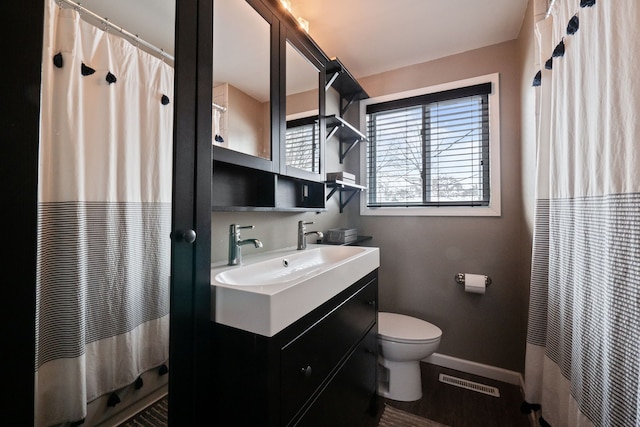 full bath featuring visible vents, curtained shower, baseboards, toilet, and vanity