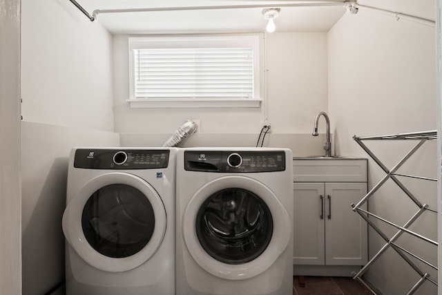 laundry area with washer and clothes dryer, cabinet space, dark tile patterned flooring, and a sink