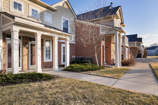 view of front facade featuring brick siding and covered porch