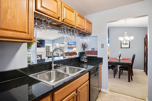 kitchen featuring light carpet, a tiled fireplace, a sink, dishwasher, and a chandelier