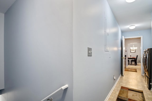 hall with baseboards and a notable chandelier