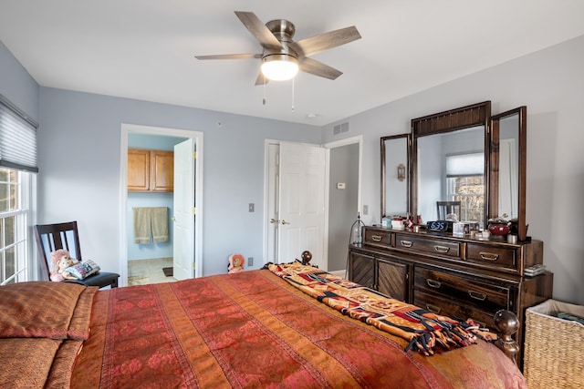 bedroom with connected bathroom, visible vents, and ceiling fan