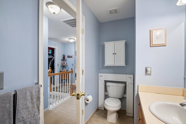 bathroom with vanity, baseboards, visible vents, tile patterned floors, and toilet