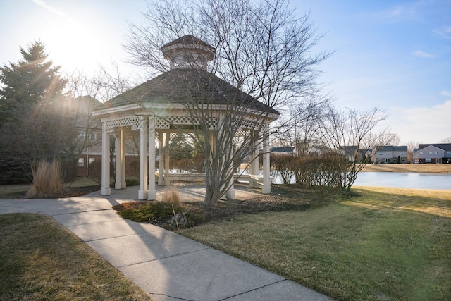 surrounding community featuring a gazebo, a water view, and a lawn