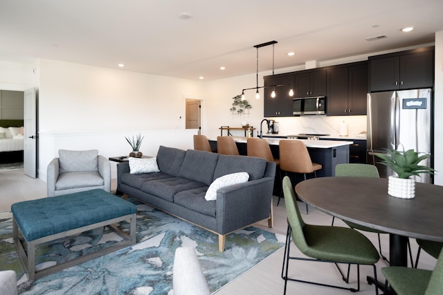 living area with recessed lighting, visible vents, and light wood-style flooring