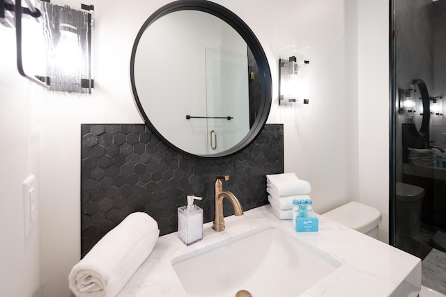 bathroom with vanity, toilet, and backsplash