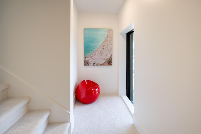 corridor featuring stairway and carpet