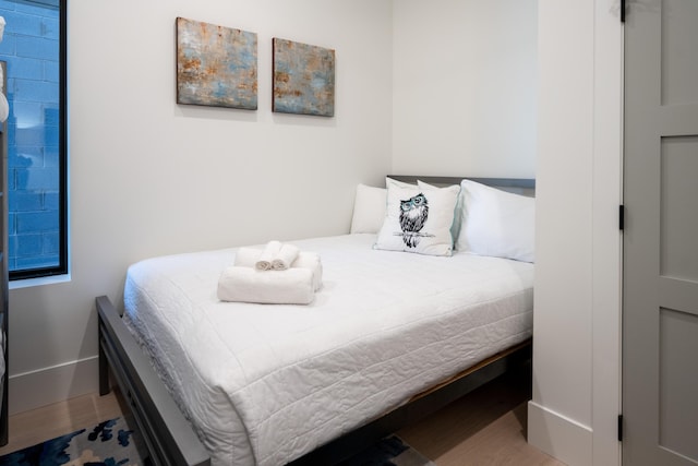 bedroom featuring baseboards and wood finished floors